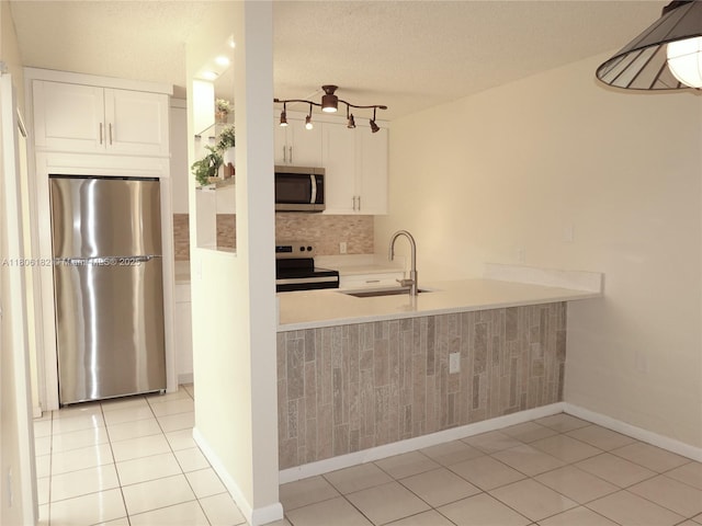 4226 42nd Way, West Palm Beach, FL 33407 - kitchen featuring appliances with stainless steel finishes, a sink, white cabinetry, light countertops, and a peninsula
