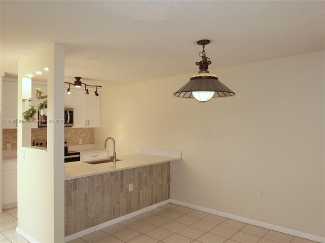 4226 42nd Way, West Palm Beach, FL 33407 - kitchen featuring stove, a sink, backsplash, stainless steel microwave, and a peninsula