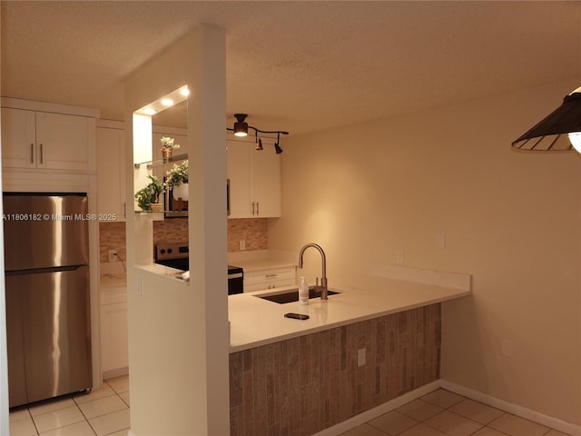 4226 42nd Way, West Palm Beach, FL 33407 - kitchen featuring freestanding refrigerator, stove, a sink, white cabinets, and light tile patterned floors