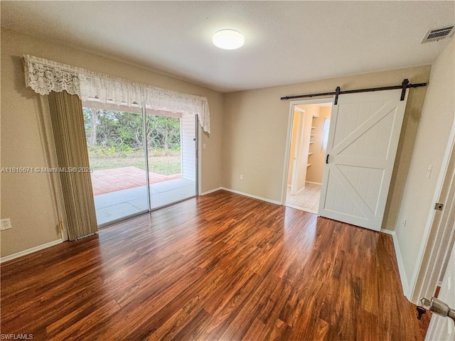 2016 Mariner Ct, La Belle, FL 33935 - empty room featuring wood finished floors, baseboards, and a barn door
