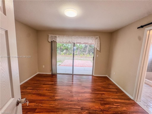 2016 Mariner Ct, La Belle, FL 33935 - unfurnished room with wood finished floors, baseboards, a barn door, and a textured ceiling