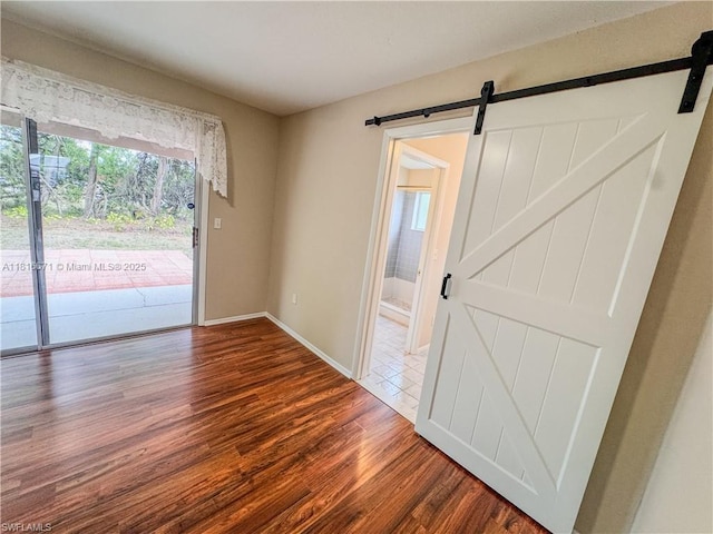 2016 Mariner Ct, La Belle, FL 33935 - spare room featuring a barn door, wood finished floors, and healthy amount of natural light