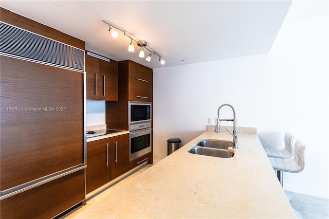 475 Brickell Ave Unit 3512, Miami, FL 33131 - kitchen featuring a sink, built in appliances, light countertops, and dark brown cabinetry