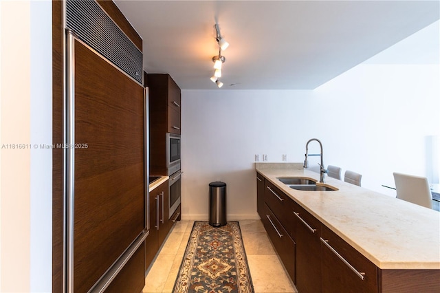 475 Brickell Ave Unit 3512, Miami, FL 33131 - kitchen with a sink, paneled built in refrigerator, modern cabinets, a peninsula, and dark brown cabinets