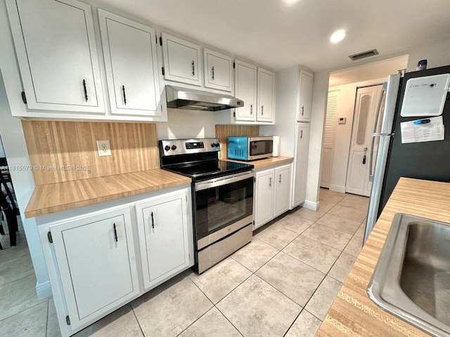 1100 Saint Charles Pl Unit 712, Pembroke Pines, FL 33026 - kitchen featuring appliances with stainless steel finishes, under cabinet range hood, light tile patterned floors, a sink, and white cabinetry