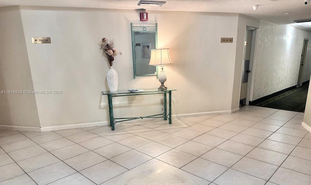 1100 Saint Charles Pl Unit 712, Pembroke Pines, FL 33026 - hall featuring tile patterned flooring, baseboards, and a textured ceiling