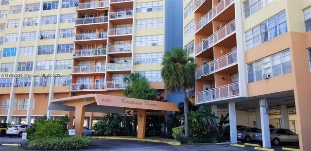 2025 NE 164th St Unit 414, North Miami Beach, FL 33162 - view of apartment building / complex featuring uncovered parking and cooling unit