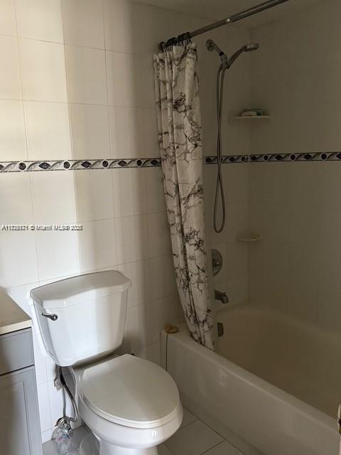 2025 NE 164th St Unit 414, North Miami Beach, FL 33162 - full bathroom featuring shower / bath combination with curtain, toilet, tile walls, and tile patterned floors