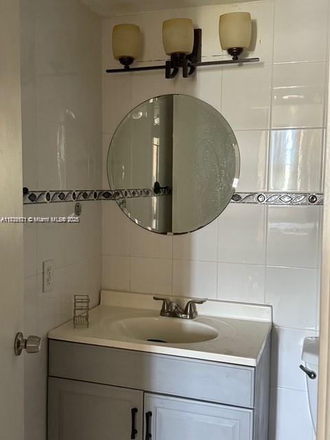 2025 NE 164th St Unit 414, North Miami Beach, FL 33162 - bathroom featuring tile walls, vanity, and backsplash