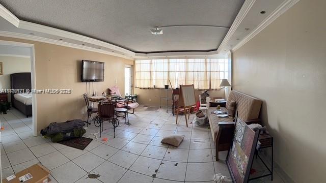 2025 NE 164th St Unit 414, North Miami Beach, FL 33162 - dining space featuring a tray ceiling, plenty of natural light, tile patterned flooring, ornamental molding, and a textured ceiling