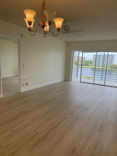 2751 N Palm Aire Dr Unit 504, Pompano Beach, FL 33069 - unfurnished room with a chandelier, baseboards, light wood-style flooring, and ceiling fan