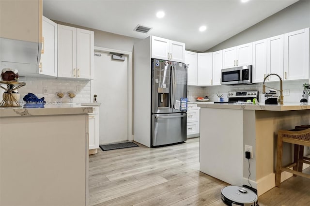 4760 SW 57th Ave, Davie, FL 33314 - kitchen with stainless steel appliances, light wood finished floors, backsplash, white cabinetry, and recessed lighting