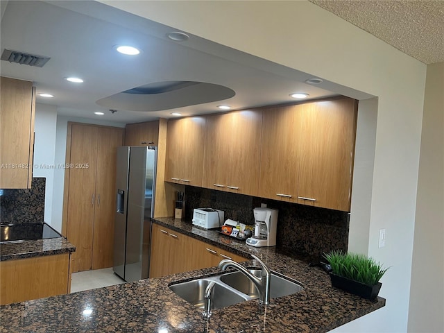 1717 N Bayshore Dr Unit A-1038, Miami, FL 33132 - kitchen with stainless steel fridge, a sink, dark stone countertops, decorative backsplash, and recessed lighting