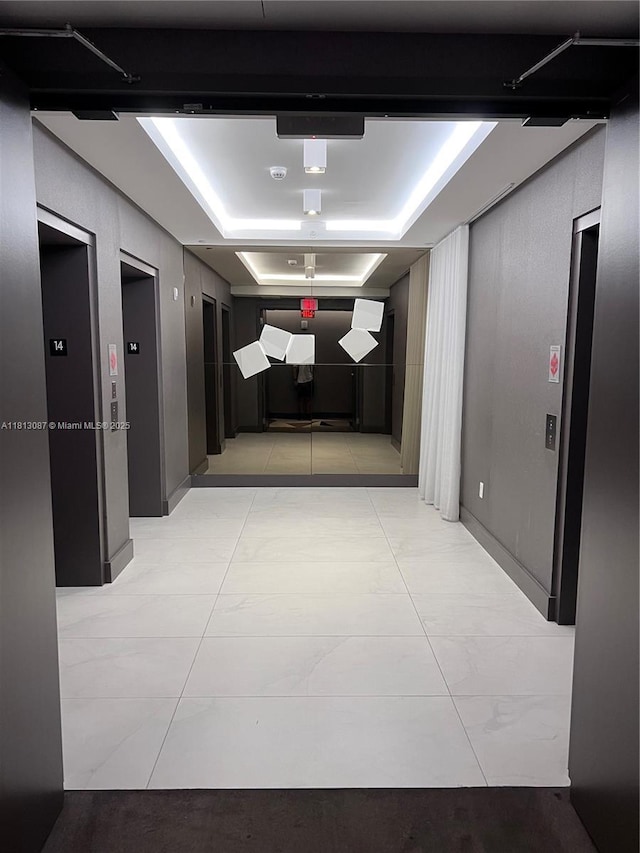 17301 Biscayne Blvd Unit 1402, North Miami Beach, FL 33160 - corridor with a raised ceiling, elevator, and light tile patterned floors