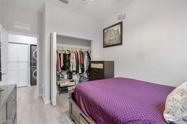 14063 SW 49th Ct Unit 4, Miramar, FL 33027 - bedroom with stacked washing machine and dryer, light wood-type flooring, and a closet
