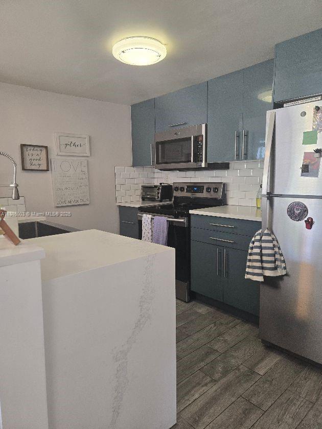 4560 SW 68th Ct Cir Unit 61-9, Miami, FL 33155 - kitchen with appliances with stainless steel finishes, tasteful backsplash, dark wood-style floors, light countertops, and a sink