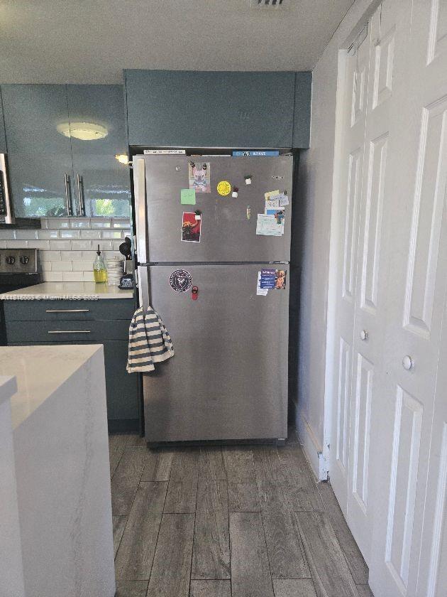 4560 SW 68th Ct Cir Unit 61-9, Miami, FL 33155 - kitchen featuring freestanding refrigerator, range, wood finished floors, light countertops, and backsplash