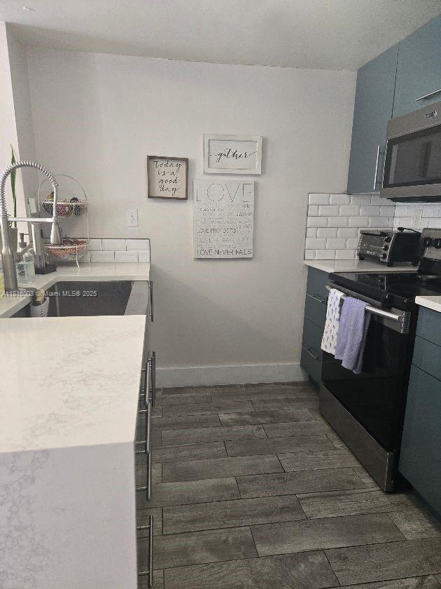 4560 SW 68th Ct Cir Unit 61-9, Miami, FL 33155 - kitchen featuring stainless steel appliances, dark wood finished floors, light countertops, and tasteful backsplash