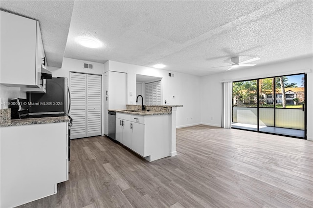 2094 Arbour Walk Unit 318, Naples, FL 34109 - kitchen with a sink, stainless steel dishwasher, a peninsula, a ceiling fan, and wood finished floors