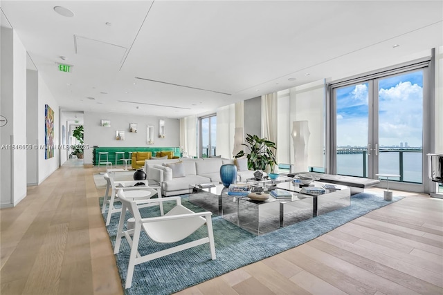 3131 NE 7th Ave Unit 1702, Miami, FL 33137 - living room featuring light wood-style flooring, expansive windows, a water view, and french doors
