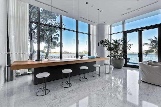 3131 NE 7th Ave Unit 1702, Miami, FL 33137 - building lobby featuring a wall of windows, a high ceiling, and a water view