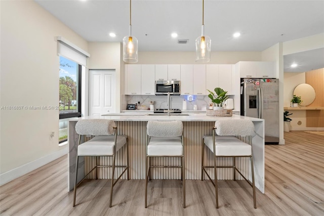 8001 NW 41st St Unit F-107, Doral, FL 33166 - kitchen featuring stainless steel appliances, light wood finished floors, light countertops, an island with sink, and recessed lighting