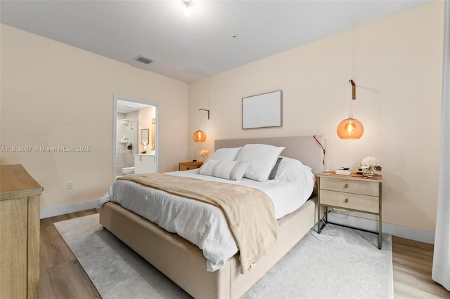 8001 NW 41st St Unit F-107, Doral, FL 33166 - bedroom with light wood finished floors, baseboards, and ensuite bath