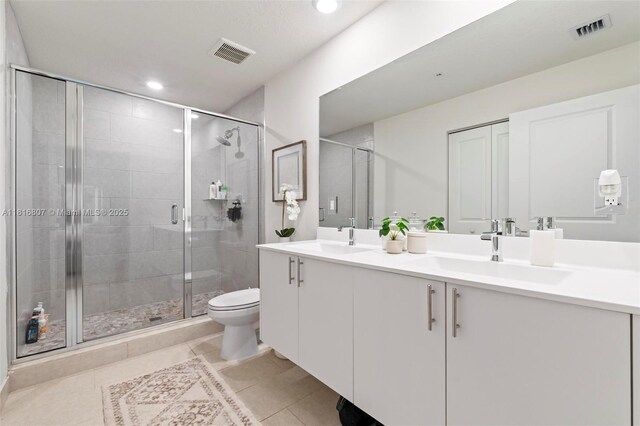 8001 NW 41st St Unit F-107, Doral, FL 33166 - bathroom featuring double vanity, toilet, a stall shower, tile patterned flooring, and recessed lighting
