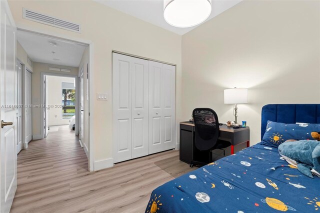 8001 NW 41st St Unit F-107, Doral, FL 33166 - bedroom featuring light wood-style floors, a closet, and baseboards