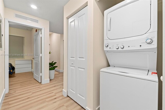 8001 NW 41st St Unit F-107, Doral, FL 33166 - washroom featuring stacked washer and clothes dryer, light wood-style floors, baseboards, and recessed lighting