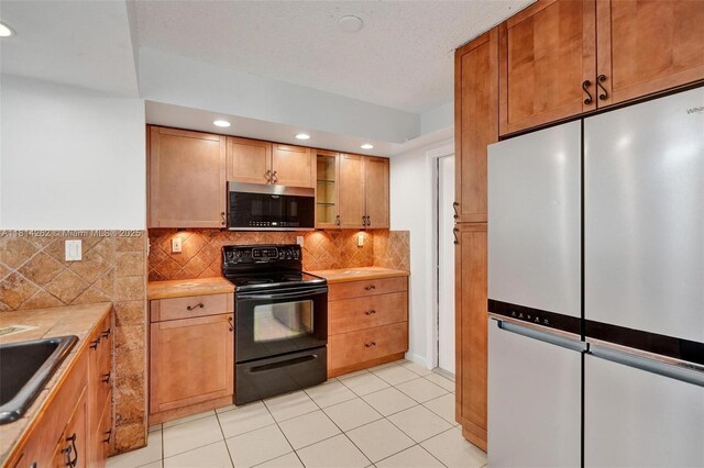 2388 NW 97th Way, Pembroke Pines, FL 33024 - kitchen with stainless steel appliances, tile counters, decorative backsplash, light tile patterned floors, and recessed lighting