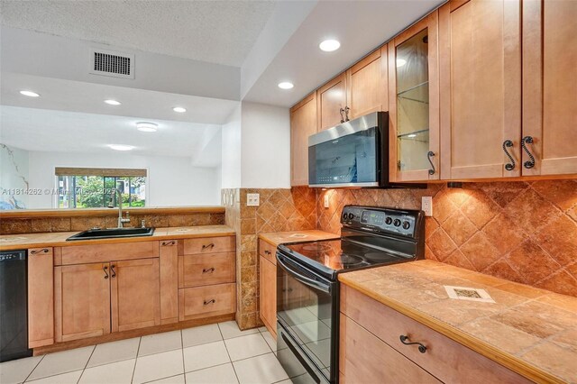 2388 NW 97th Way, Pembroke Pines, FL 33024 - kitchen featuring black appliances, glass insert cabinets, recessed lighting, tile counters, and light tile patterned flooring