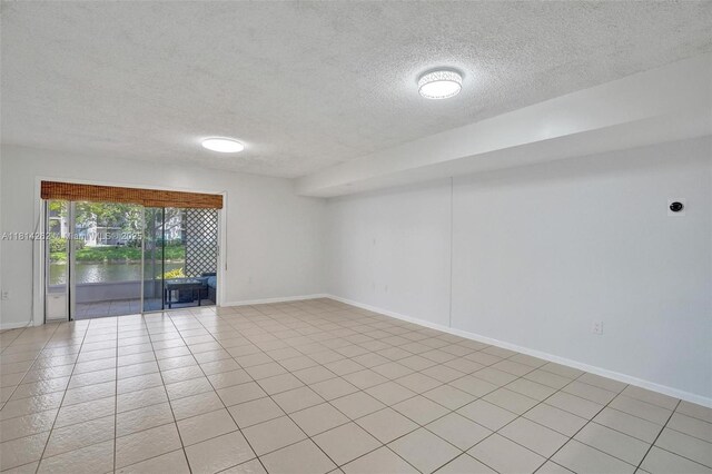 2388 NW 97th Way, Pembroke Pines, FL 33024 - unfurnished room featuring a textured ceiling, a water view, and light tile patterned floors
