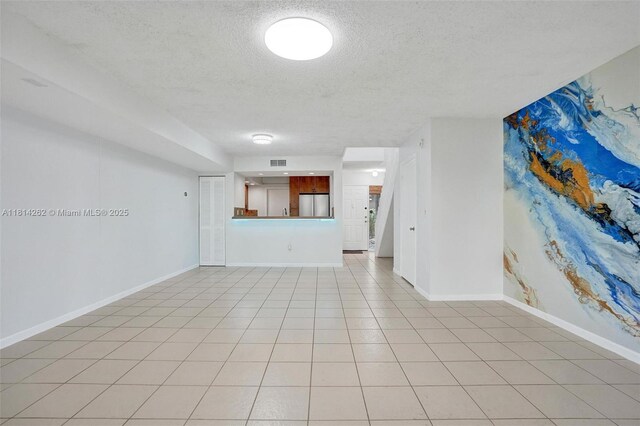 2388 NW 97th Way, Pembroke Pines, FL 33024 - unfurnished living room with a textured ceiling and light tile patterned flooring