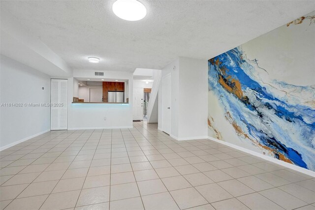 2388 NW 97th Way, Pembroke Pines, FL 33024 - unfurnished living room with a textured ceiling and light tile patterned floors