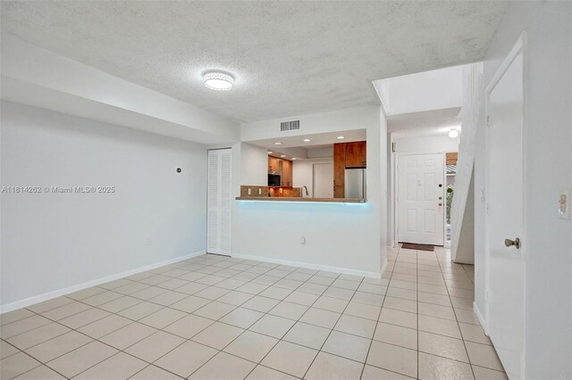 2388 NW 97th Way, Pembroke Pines, FL 33024 - unfurnished living room with a textured ceiling and light tile patterned floors