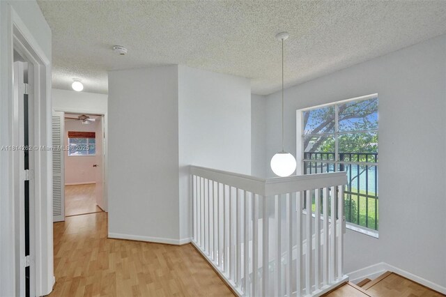 2388 NW 97th Way, Pembroke Pines, FL 33024 - hallway with an upstairs landing, a textured ceiling, and light wood-style floors