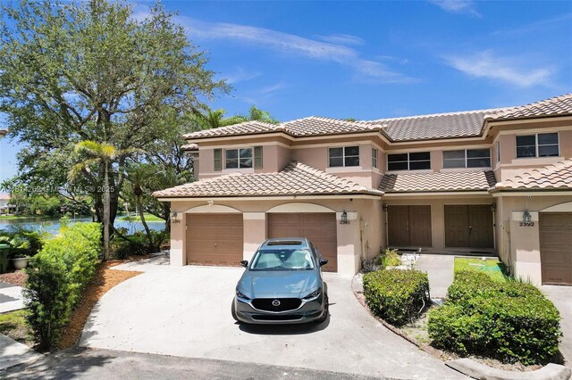 2388 NW 97th Way, Pembroke Pines, FL 33024 - view of front of house featuring concrete driveway, stucco siding, a tiled roof, and a water view