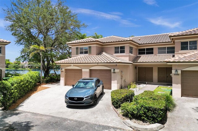 2388 NW 97th Way, Pembroke Pines, FL 33024 - view of front of home with stucco siding, driveway, a tile roof, and a water view