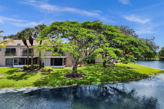 2388 NW 97th Way, Pembroke Pines, FL 33024 - back of house with a sunroom, a water view, stucco siding, and a lawn