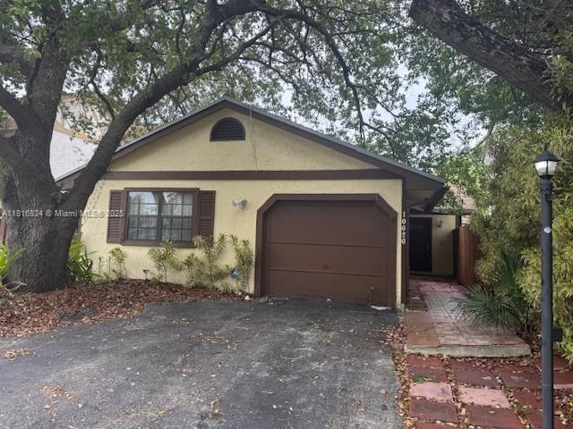 10626 SW 148th Ave Dr, Miami, FL 33196 - view of front of home featuring stucco siding, an attached garage, and driveway