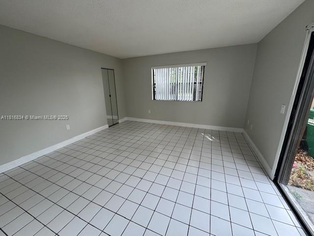10626 SW 148th Ave Dr, Miami, FL 33196 - empty room with light tile patterned flooring and baseboards