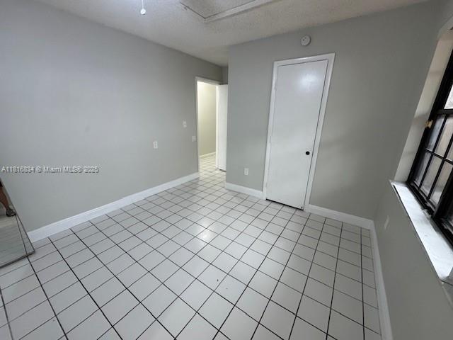 10626 SW 148th Ave Dr, Miami, FL 33196 - spare room featuring baseboards, light tile patterned floors, and a smoke detector