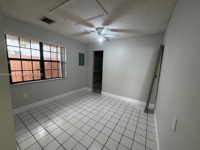 10626 SW 148th Ave Dr, Miami, FL 33196 - empty room featuring a textured ceiling, a ceiling fan, light tile patterned floors, electric panel, and baseboards