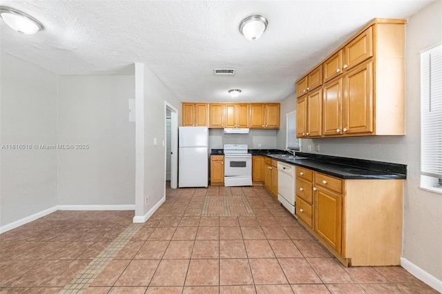 6359 SW 1st St, Margate, FL 33068 - kitchen with white appliances, a sink, under cabinet range hood, dark countertops, and baseboards