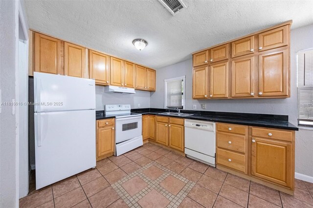 6359 SW 1st St, Margate, FL 33068 - kitchen featuring white appliances, under cabinet range hood, a sink, dark countertops, and a textured ceiling