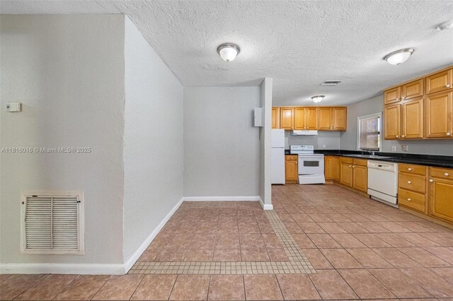 6359 SW 1st St, Margate, FL 33068 - kitchen featuring white appliances, baseboards, a sink, dark countertops, and a textured ceiling