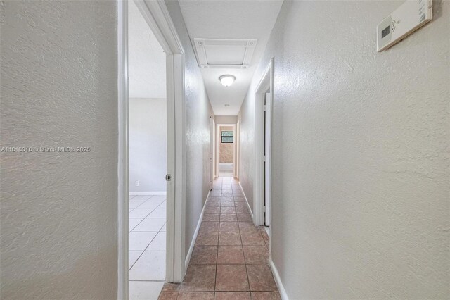 6359 SW 1st St, Margate, FL 33068 - hall featuring a textured wall, tile patterned floors, attic access, and baseboards