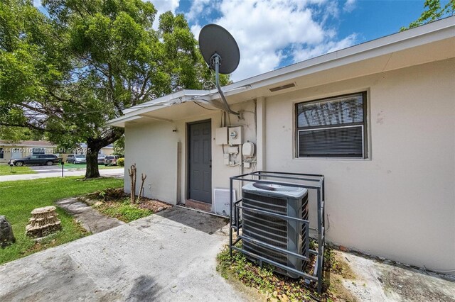 6359 SW 1st St, Margate, FL 33068 - property entrance with stucco siding, a lawn, and a cooling unit