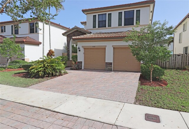 9120 SW 227th Ter, Cutler Bay, FL 33190 - mediterranean / spanish home featuring stucco siding, a tiled roof, decorative driveway, an attached garage, and stone siding